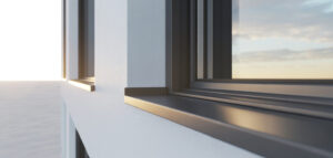 Fönsterbleck med korrekt lutning, minimalistisk design, svart metall mot vit vägg, solljus.