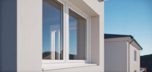 Nyinstallerad vit PVC-fönsterram på en modern husfasad, fotograferad i solljus.