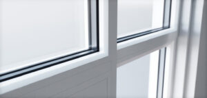 Närbild av ett modernt vitt PVC-fönster, med fokus på ren design och ljusinsläpp.